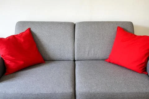 Grey sofa close-up view with red cushions Stock Photos