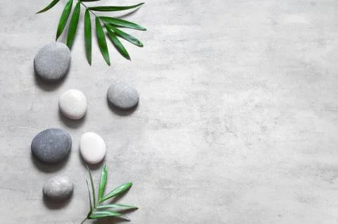 Grey spa background, spa concept, palm leaves and grey stones, top view. Foto stock