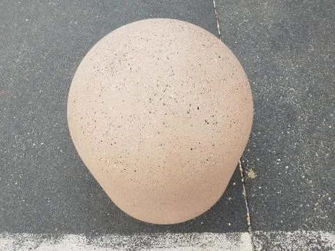 Grey spherical rock or stone on asphalt Stock Photos