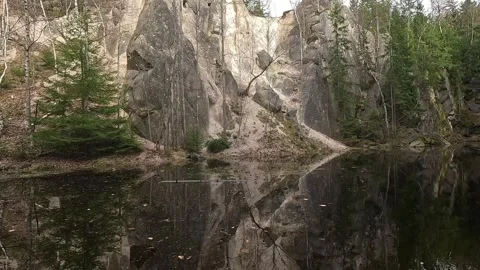 Grey steep cliffs on the shore of a mountain lake. Rudawskie Mountains Stock Footage 295189118