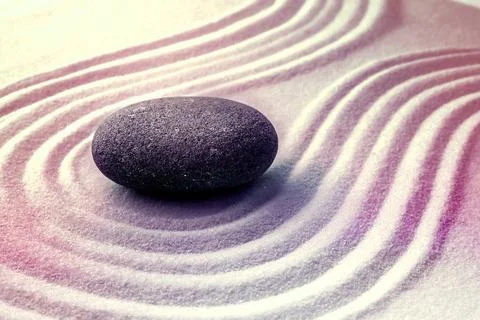Grey stone on sand with pattern. Zen, meditation, harmony Stock Photos