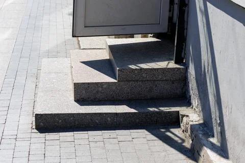 Grey stone steps lead to a partially open door Stock Photos