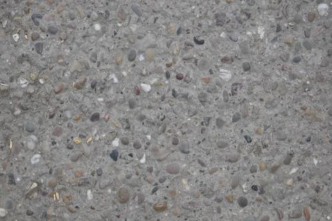A grey stone surface with many small rocks scattered across it Stock Photos