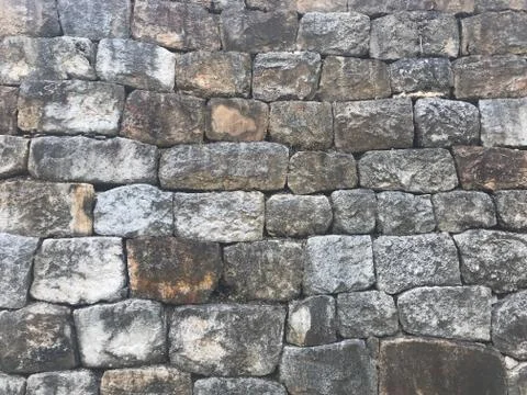 Grey stone wall as a background texture Stock Photos