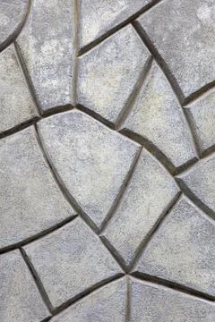 Grey stone wall made of of irregular geometric shapes Stock Photos