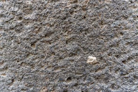 A grey stone wall with a rough texture Stock Photos