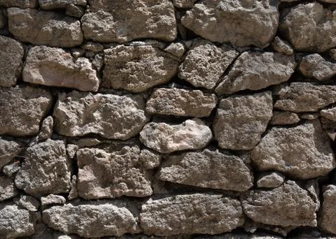 Grey stone wall texture with bright sunlight Stock Photos