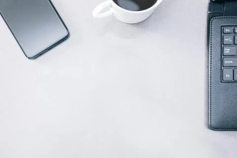 Grey table with a mobile phone, a tablet and a cup of coffee Stock Photos