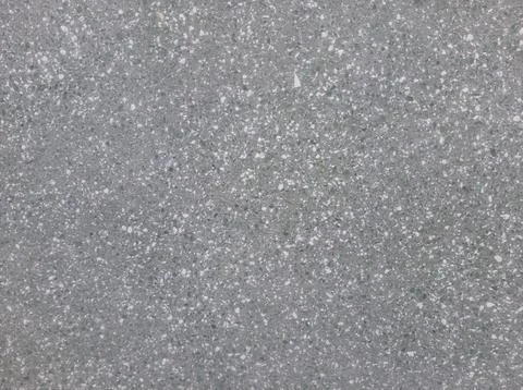 A grey terrazzo surface is visible with small green and white chips scattered Stock Photos