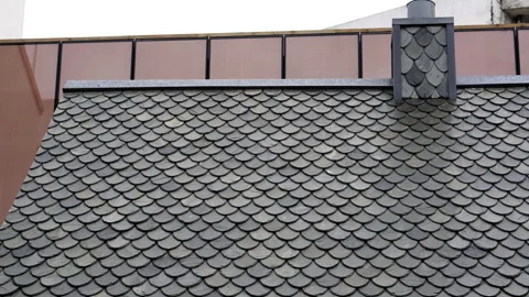 Grey tiles fish-scale tiles roofing over European house roof and chimney Stock Footage 152233232