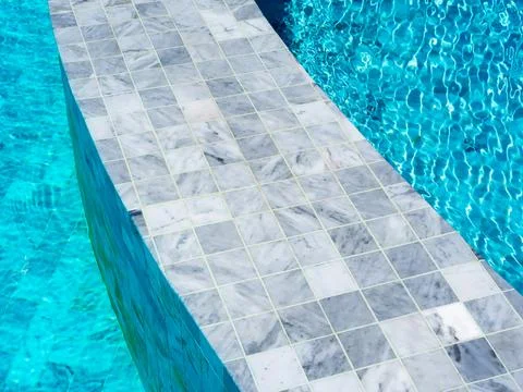 Grey tiles with small grid pattern, empty space on the poolside edge for obje Stock Photos