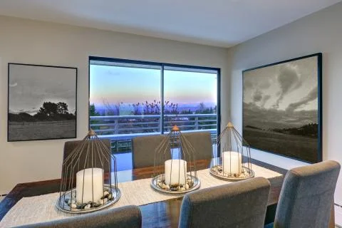 Grey tones dining space is fitted with dark wood dining table with decorative Stock Photos
