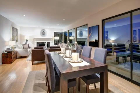 Grey tones dining space is fitted with dark wood dining table with decorative Stock Photos