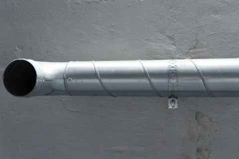 Grey vent pipe is fixed on grey ceiling wall fasteners Stock Photos