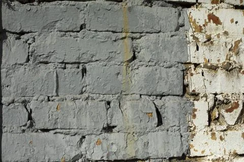 Grey wall. Painted bricks removed coarsely. Details of old building. Stock-Fotos