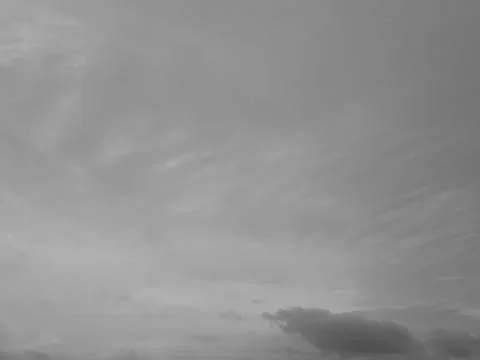 Grey white cloudscape background with smooth cloud shapes and sunlight. Stock Photos