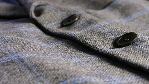 Grey wool blazer with blue plaid pattern and dark buttons close-up details.  Stock Footage 346656272