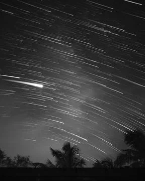 Greyscale of the effect of shiny falling stars in the night sky Foto stock