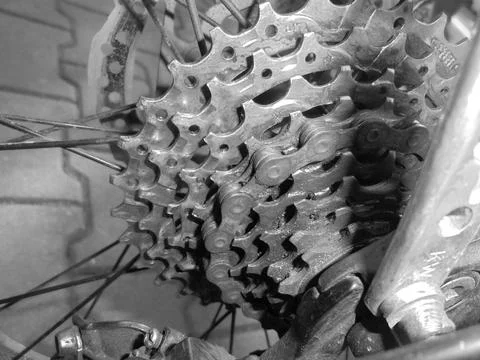 Greyscaled image - Close-up on nine speed mountain bike gear with chain. Stock Photos