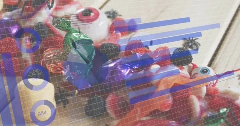 Grid, bar charts fading over Halloween candy bowl, donut cycling, camera tilting Stock Footage 317485934