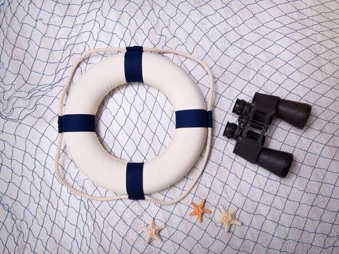 Grid, circle, binoculars and starfish on a wooden background. Stock Photos