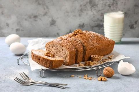 Grid with delicious walnut loaf cake and eggs on blue grunge background Stock Photos