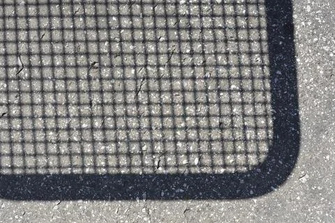 Grid mesh shadow with a rounded corner on asphalt surface texture Stock Photos