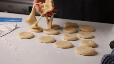 Grid pattern cookies with dough ribbons over small dough balls on white Stock Footage 347459622