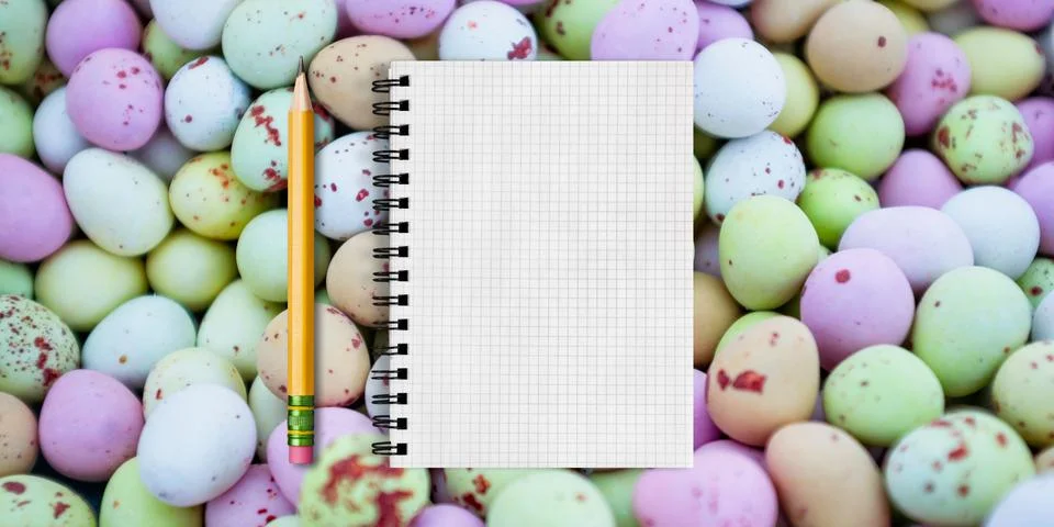 A grid-patterned notebook page is open, spiraled on the left, surrounded by colo Stock Photos