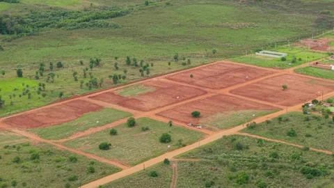 Gridded farmland plots with reddish soil in an open countryside landscape Stock Footage 309080237
