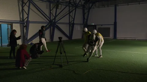 Gridiron Football Players Practicing Blocking and Tackling for TV Show at Arena Stock Footage 335397330
