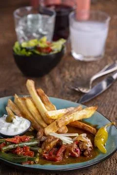 Griechisches Gyros mit Metaxasauce und Pommes frites Griechisches Gyros mi... Stock Photos