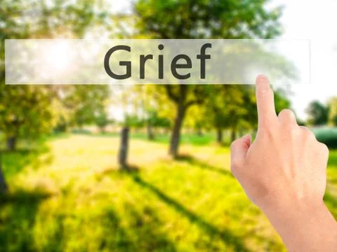 Grief - Hand pressing a button on blurred background concept on visual screen Fotos de archivo