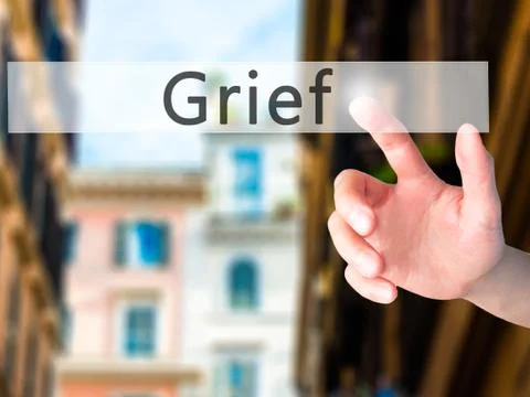 Grief - Hand pressing a button on blurred background concept on visual screen Fotos de archivo