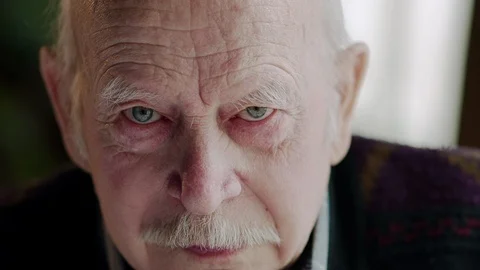 Grief-stricken old man with red rimmed eyes looking at the camera before wiping Stock Footage 88533257