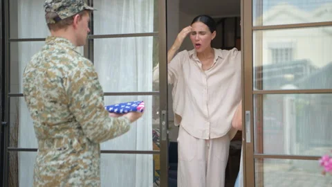 Grieving family receiving folded flag from soldier at doorstep, Stock Footage 340153947