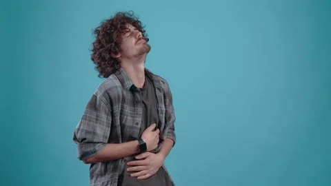 The grieving young man clings to his stomach, feels an acute pain that makes him Stock Footage 152903559