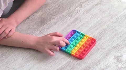 Gril presses bubbles on morden silicone toy pop it. Anti stress sensory toy Stock Footage 155469596