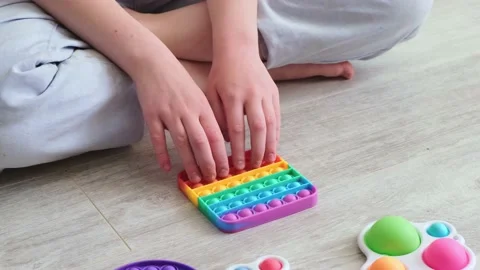 Gril presses bubbles on morden silicone toy pop it. Anti stress sensory toy Stock Footage 155663624