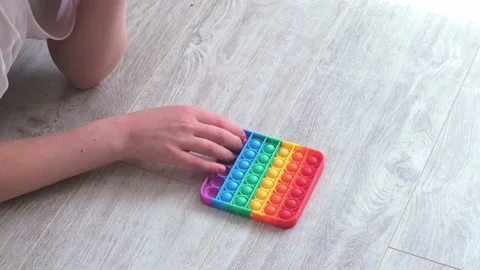Gril presses bubbles on morden silicone toy pop it. Anti stress sensory toy Stock Footage 155752302