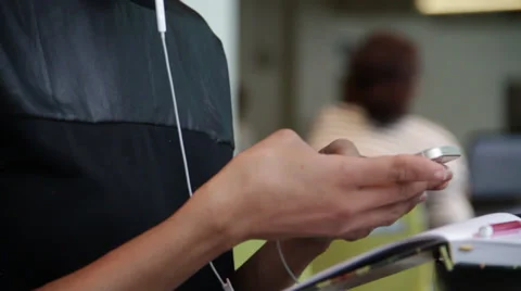 A gril texting on phone while hearing songs in earphones Stock Footage 36173688
