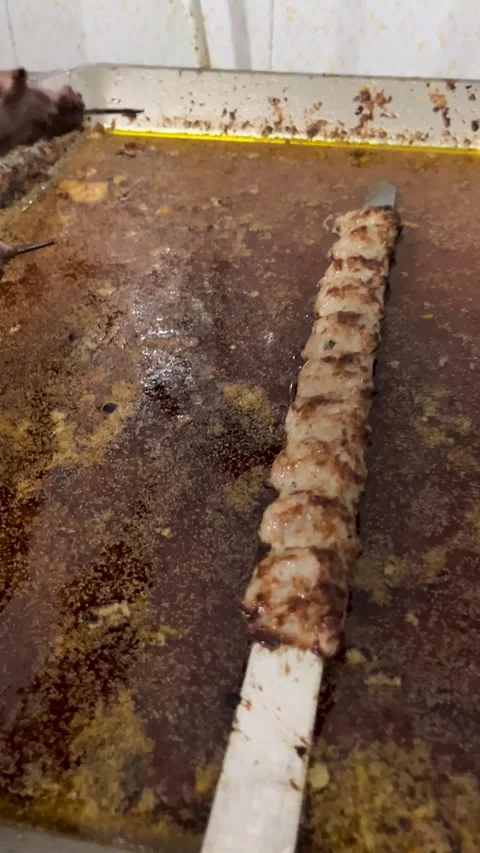 Grill in action with multiple skewers of minced meat kebabs over open flame Video stock 309655827