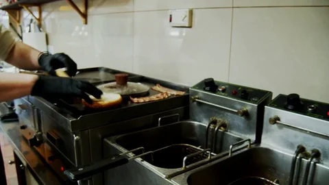 Grill burger hamburger bacon bake professional kitchen moving camera Video stock 129106879