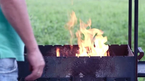 Grill with a burning fire and blurred fragment of a man Stock-Footage 158431835