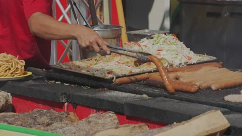 Grill cook grabs large hot dog with tongs slow motion Stock Footage 201961816