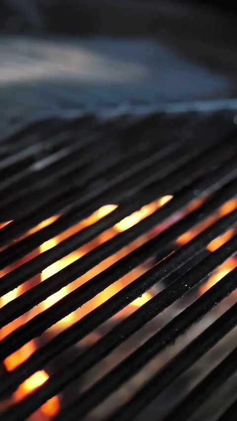 Grill. Empty black grill grid on fire background. rotating large grill in a Stock Footage 318351179