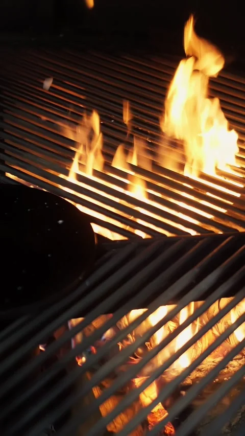 Grill. Empty black grill grid on fire background. rotating large grill in a Stock Footage 320610732