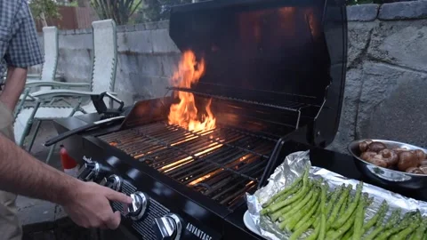 Grill fire with knobs being turned on and off to stop the fire.  Veggies 動画素材 136515287