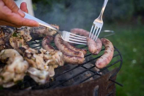 Grill garden party with sausages and meat on hot briquettes Stock Photos