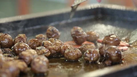 Grill the meatballs on a hot grill while stirring Stock Footage 268515802